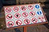 Forbuds skilt. Skilt med forbud imod videooptagelse, rygning, v�ben, paraplyer, stokke, ber�ring, spytte, mad, sidde, r�de, affald og hunde i Angkor Archeological Park, World Heritage Site  Angkor Archeological Park / Siem Reap Cambodia   Angkor Wat, Templer, Khmer riget